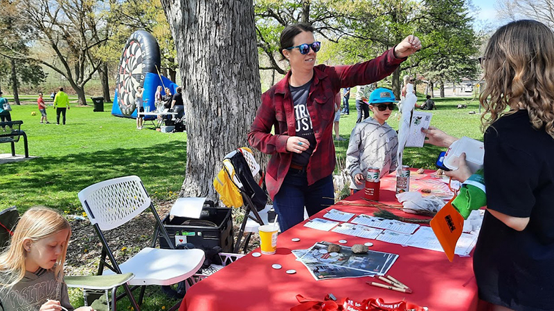 Ann Powers hands out tree seedlings to people at the 2023 Arbor Day LNK celebration.