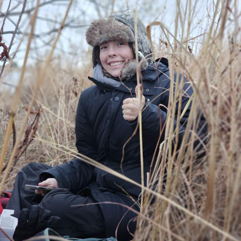 Maddy Vasquez hids in native grasses