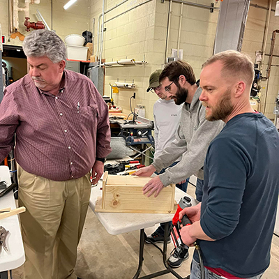Larkin Powell and John Benson help in constructing squirrel houses