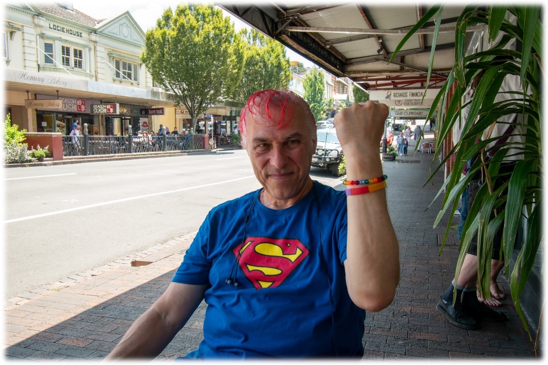 Robin outside of the coffee shop, showing off his bracelets